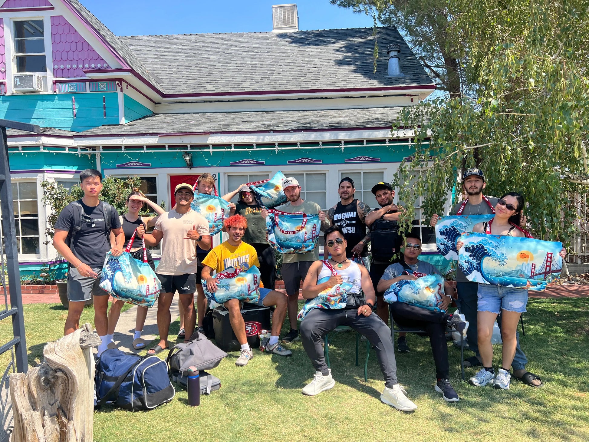 Group of travelers and creatives holding exclusive oversized designer tote bags in front of a house